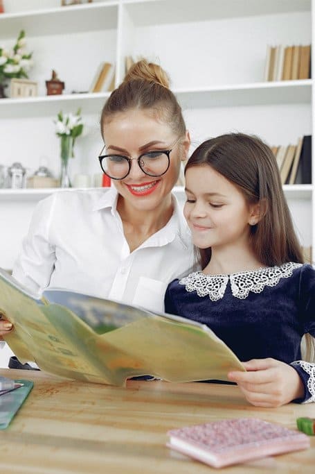 Mujer leyendo junto a una niña