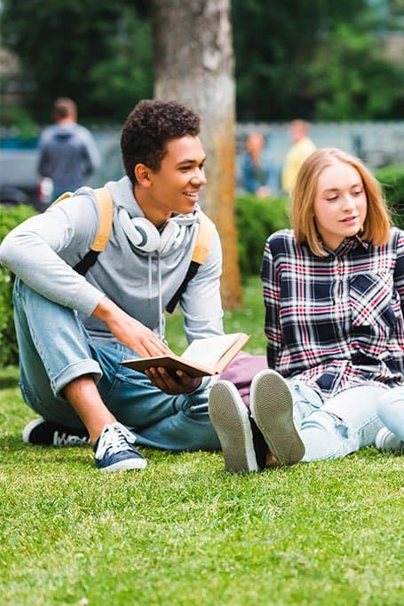 jóvenes estuidantes leyendo en el parque