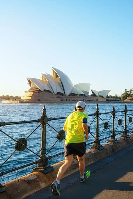 hombre corriendo frente al Opera House de Sydney