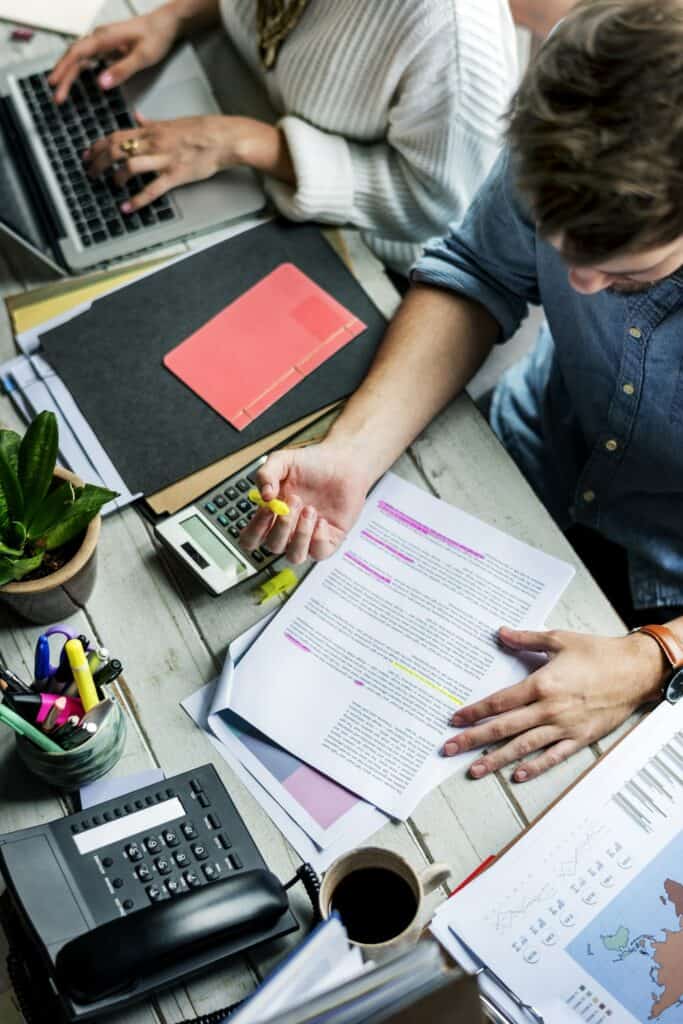 Periodista leyendo un papel y resaltando lo importante