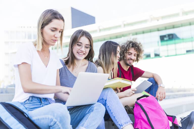 universitarios estudiando felices al aire libre