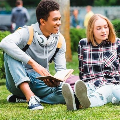 jóvenes estuidantes leyendo en el parque