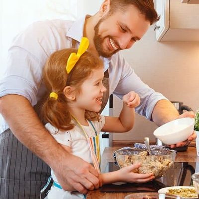 hombre enseñando a cocinar a una niña