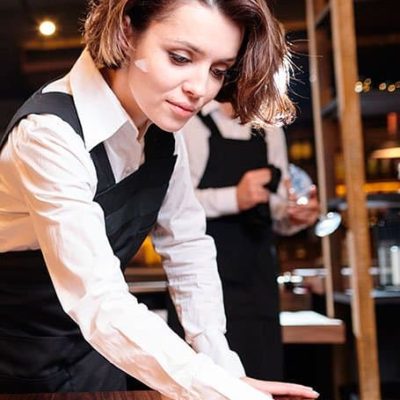 joven limpiando mesa de restaurant